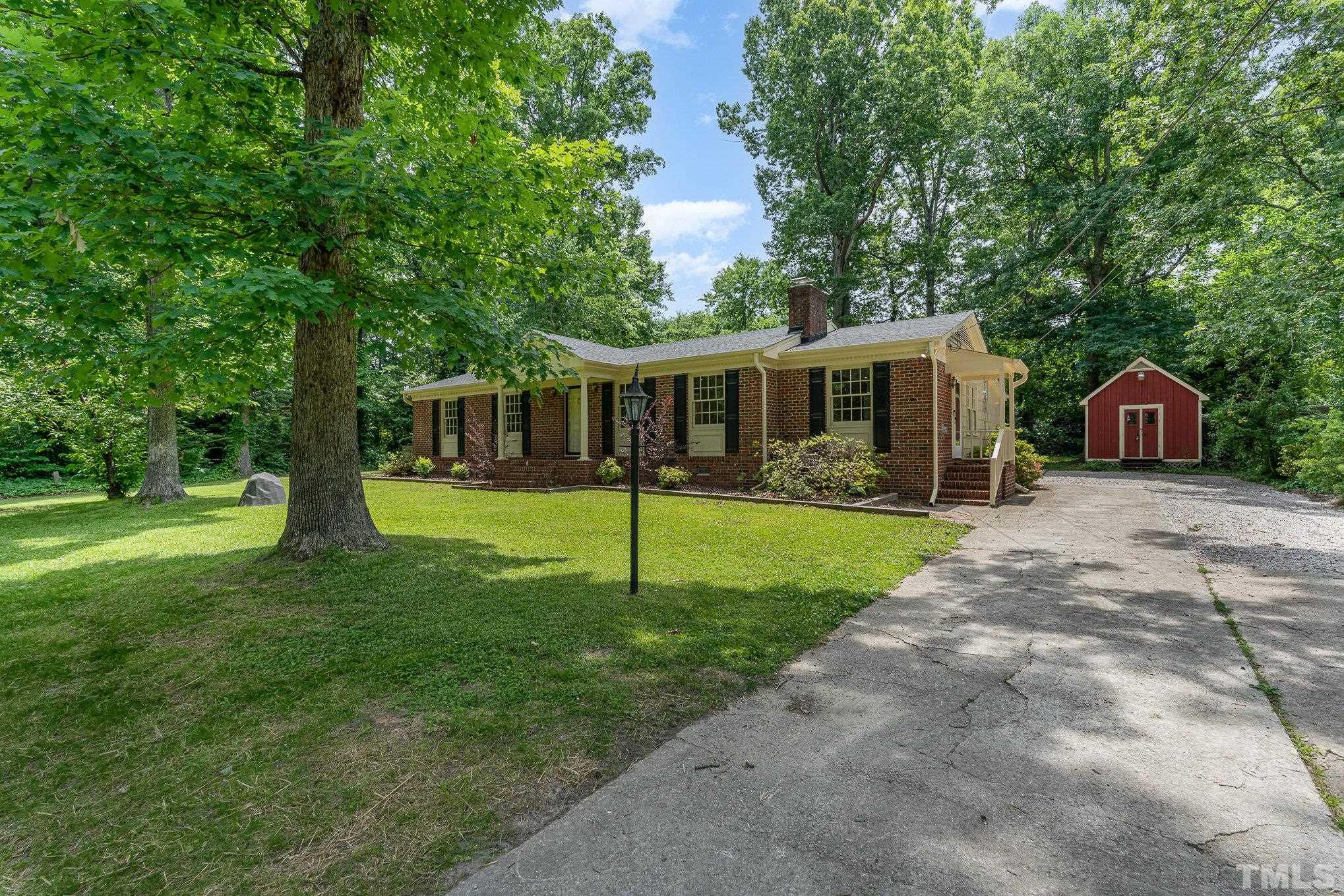 a view of a house with backyard and a tree