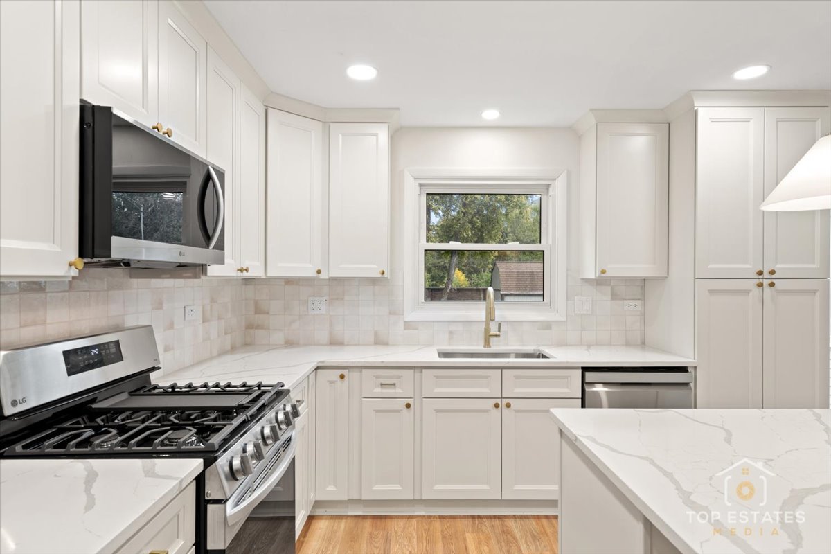 1408 Swallow Street Naperville, IL 60565 - Photo 12 of 54 a kitchen with granite countertop a sink a stove a microwave and cabinets