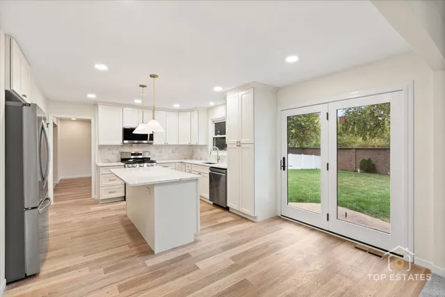 a kitchen with stainless steel appliances granite countertop a refrigerator stove and oven