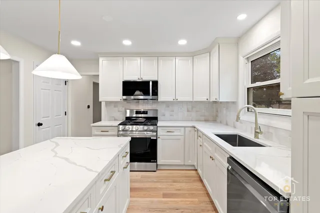 a kitchen with stainless steel appliances a stove refrigerator and a fireplace