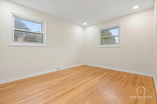 a view of empty room with wooden floor