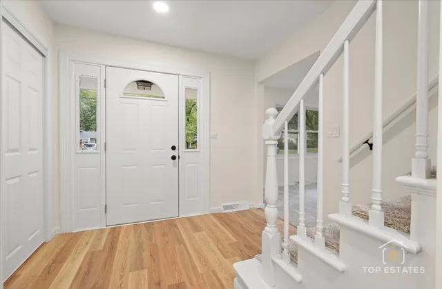 a view of a bedroom with wooden floor and windows