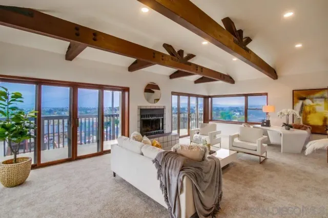 a living room with furniture a floor to ceiling window and a flat screen tv