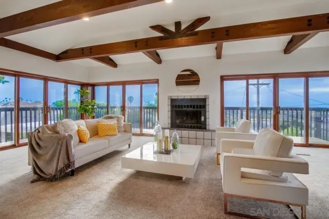 a living room with furniture fireplace and a large window