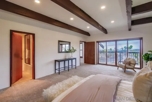 a spacious bedroom with a bed and a chandelier