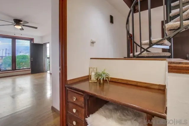 a view of staircase with lots of frames on wall and a window