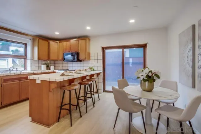 a kitchen with stainless steel appliances kitchen island granite countertop a dining table chairs and granite counter tops