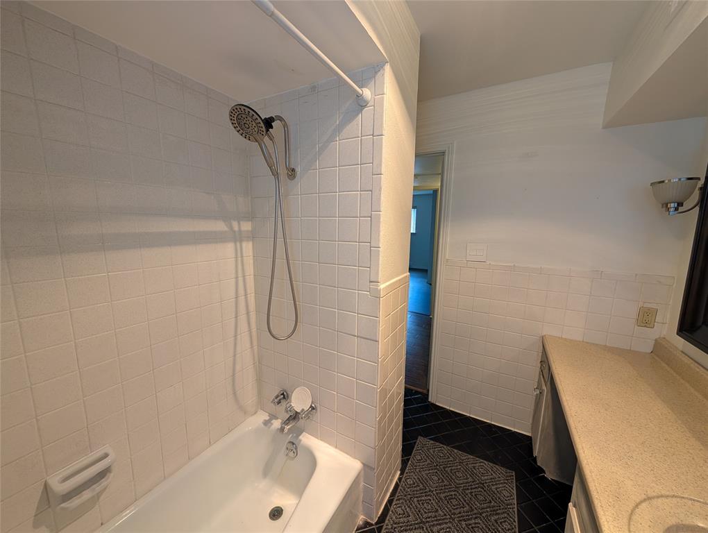 4715 Skillman Street, Unit A Dallas, TX 75206 - Photo 18 of 28 White tiled bath/shower combination with a chrome shower head and faucet
