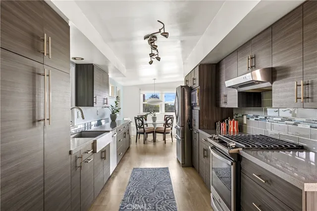 a kitchen with stainless steel appliances a sink stove and refrigerator