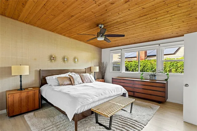 a bedroom with a bed wooden floor and window