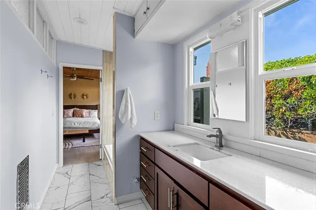 a en suite bathroom with a granite countertop sink and a window