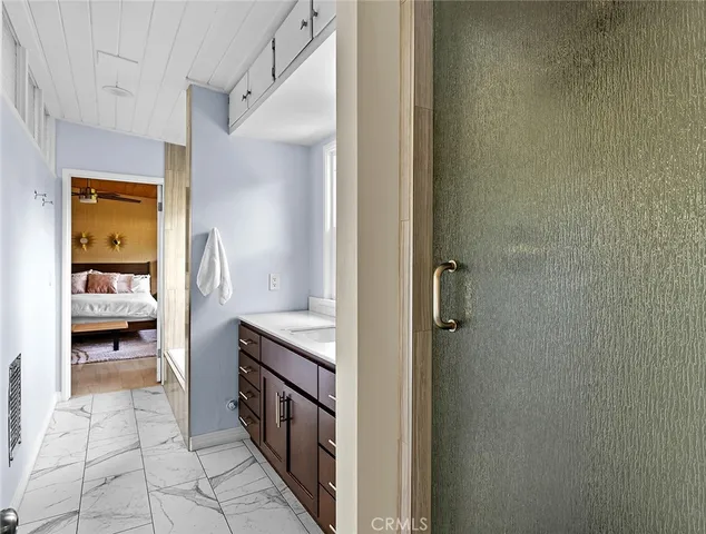 a en suite bathroom with a granite countertop sink and a mirror