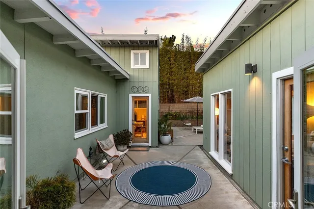 a view of a patio with couple of chairs and a fountain
