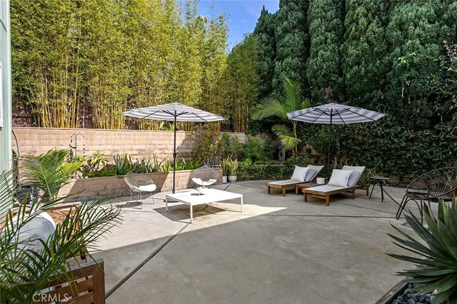 a view of a patio with a table and chairs under an umbrella