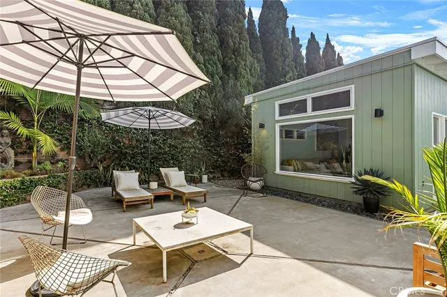 a patio with a table and chairs under an umbrella