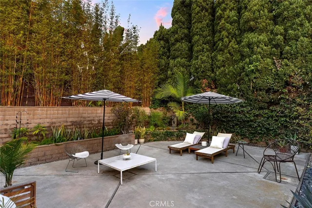 a view of a patio with a table and chairs under an umbrella