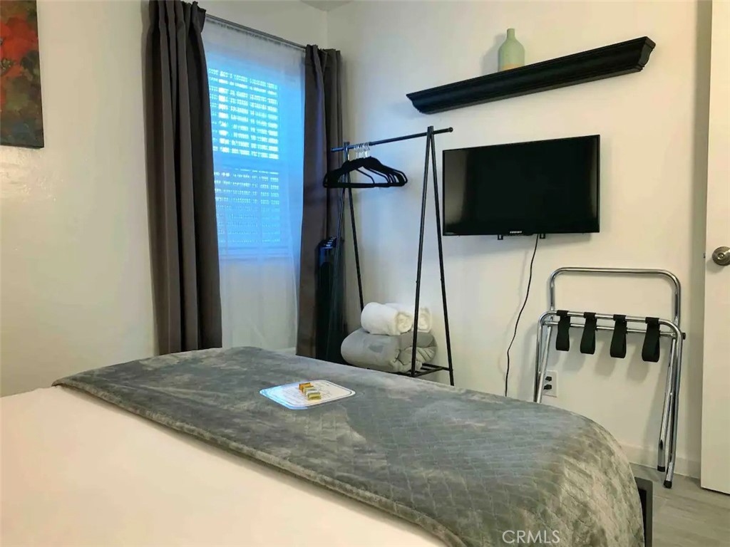 15133 Bellflower Boulevard Bellflower, CA 90706 - Photo 12 of 16 a bedroom with a bed and a flat screen tv