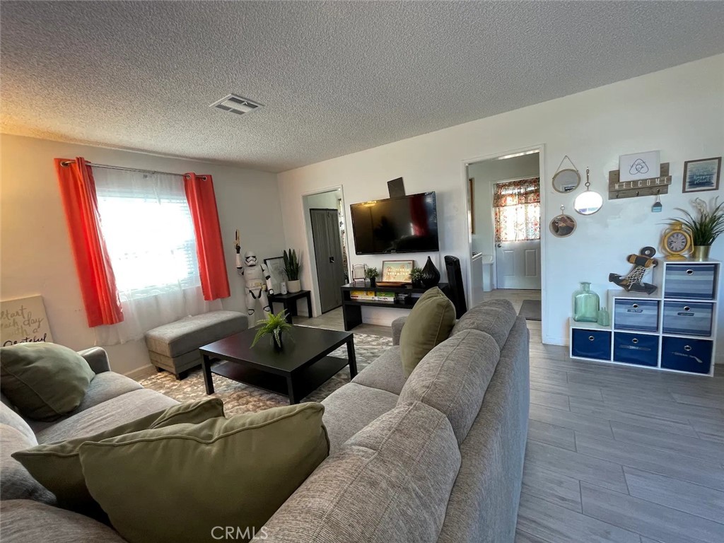 15133 Bellflower Boulevard Bellflower, CA 90706 - Photo 4 of 16 a living room with furniture and a flat screen tv