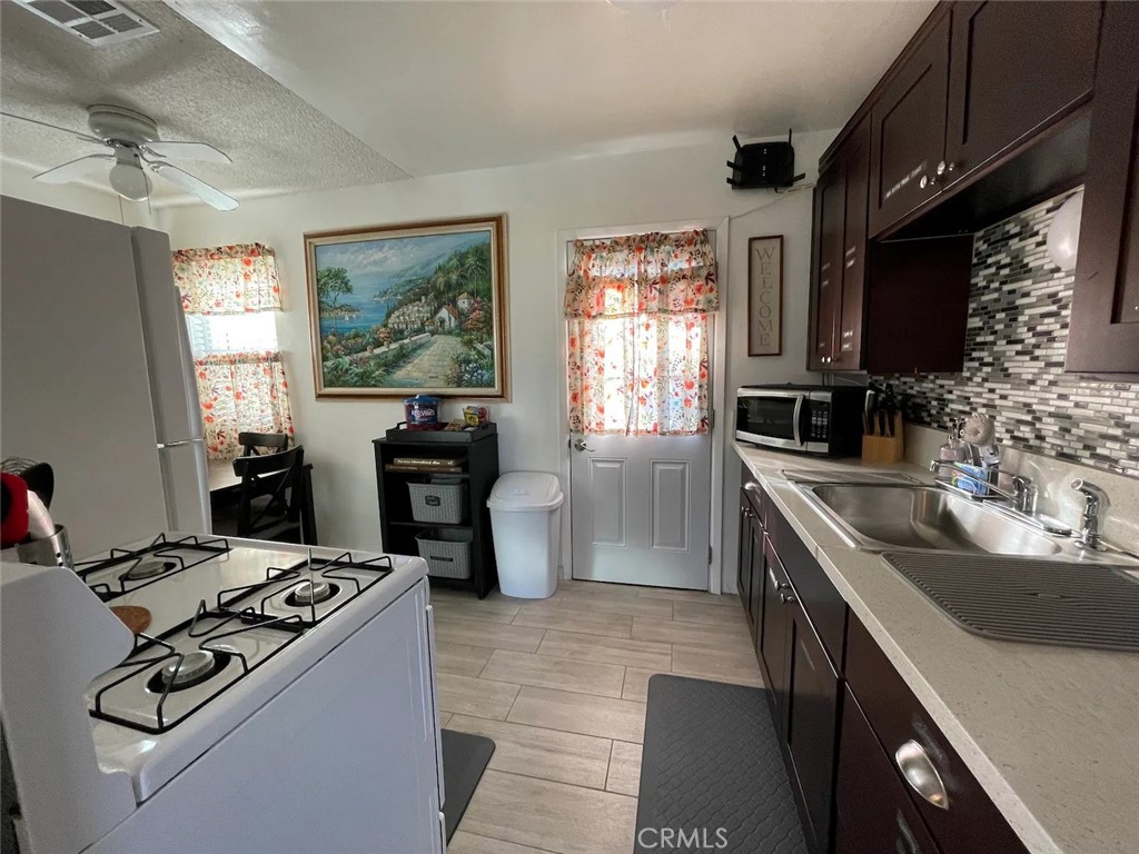 15133 Bellflower Boulevard Bellflower, CA 90706 - Photo 6 of 16 a kitchen with kitchen island a sink stove top oven and microwave