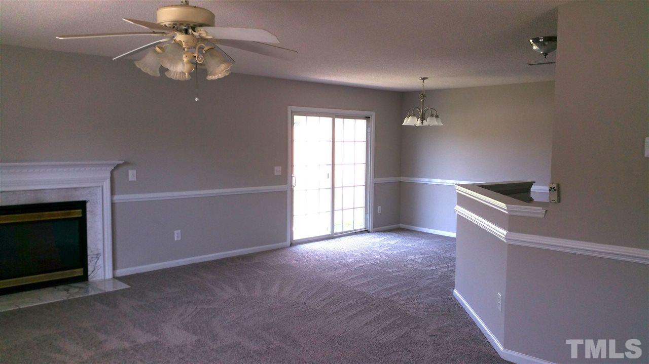 4301 Standing Rock Way Raleigh, NC 27604 - Photo 3 of 22 an empty room with chandelier fan and fireplace