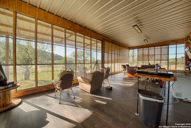 a living room with furniture a flat screen tv and a large window