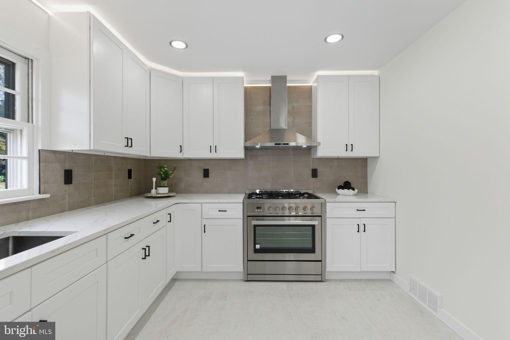 151 Dolington Road Yardley, PA 19067 - Photo 10 of 39 a kitchen with stainless steel appliances granite countertop a stove a sink and white cabinets