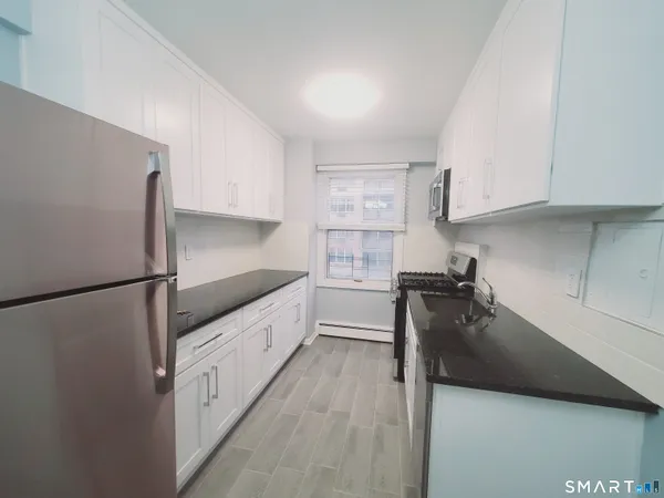 a kitchen with a refrigerator a stove a sink and white cabinets