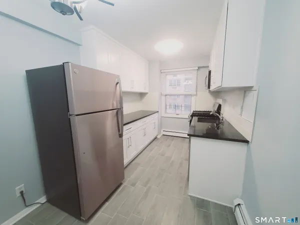 a kitchen with a refrigerator sink stove and cabinets