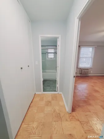 a view of a room with wooden floor and a bathroom