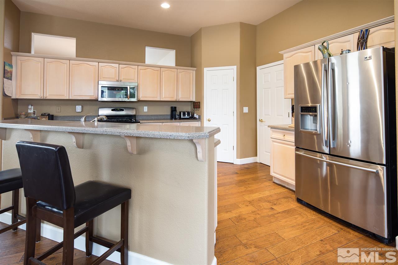 9601 Glen Ridge Drive Reno, NV 89521 - Photo 8 of 25 a kitchen with stainless steel appliances a refrigerator a stove a table and chairs