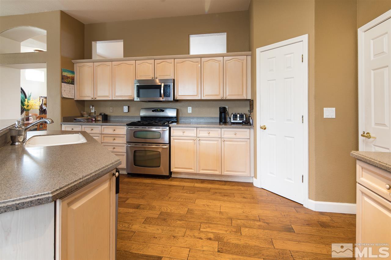 9601 Glen Ridge Drive Reno, NV 89521 - Photo 9 of 25 a kitchen with stainless steel appliances granite countertop a stove a sink and a refrigerator