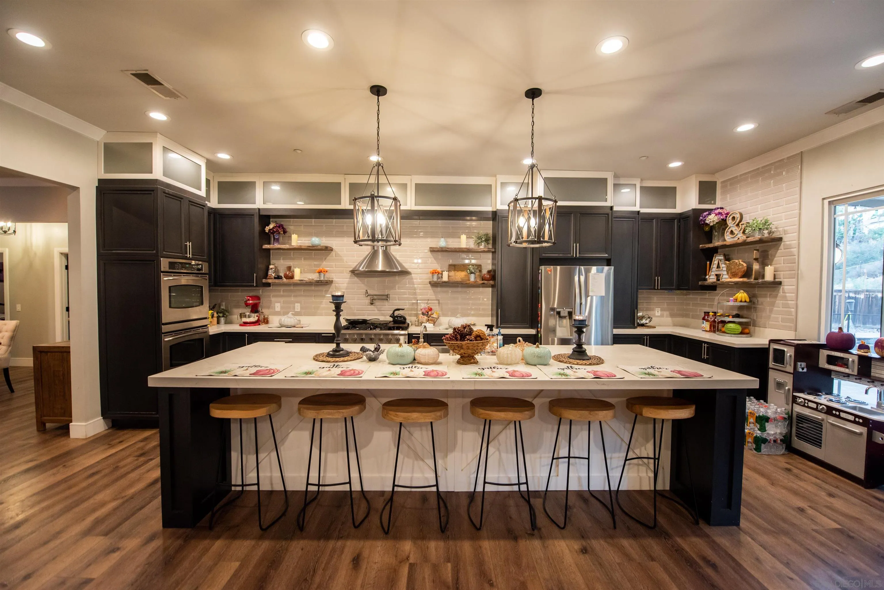 8945 Diamondback Drive Santee, CA 92071 - Photo 12 of 49 a kitchen with stainless steel appliances kitchen island granite countertop a table chairs stove and refrigerator