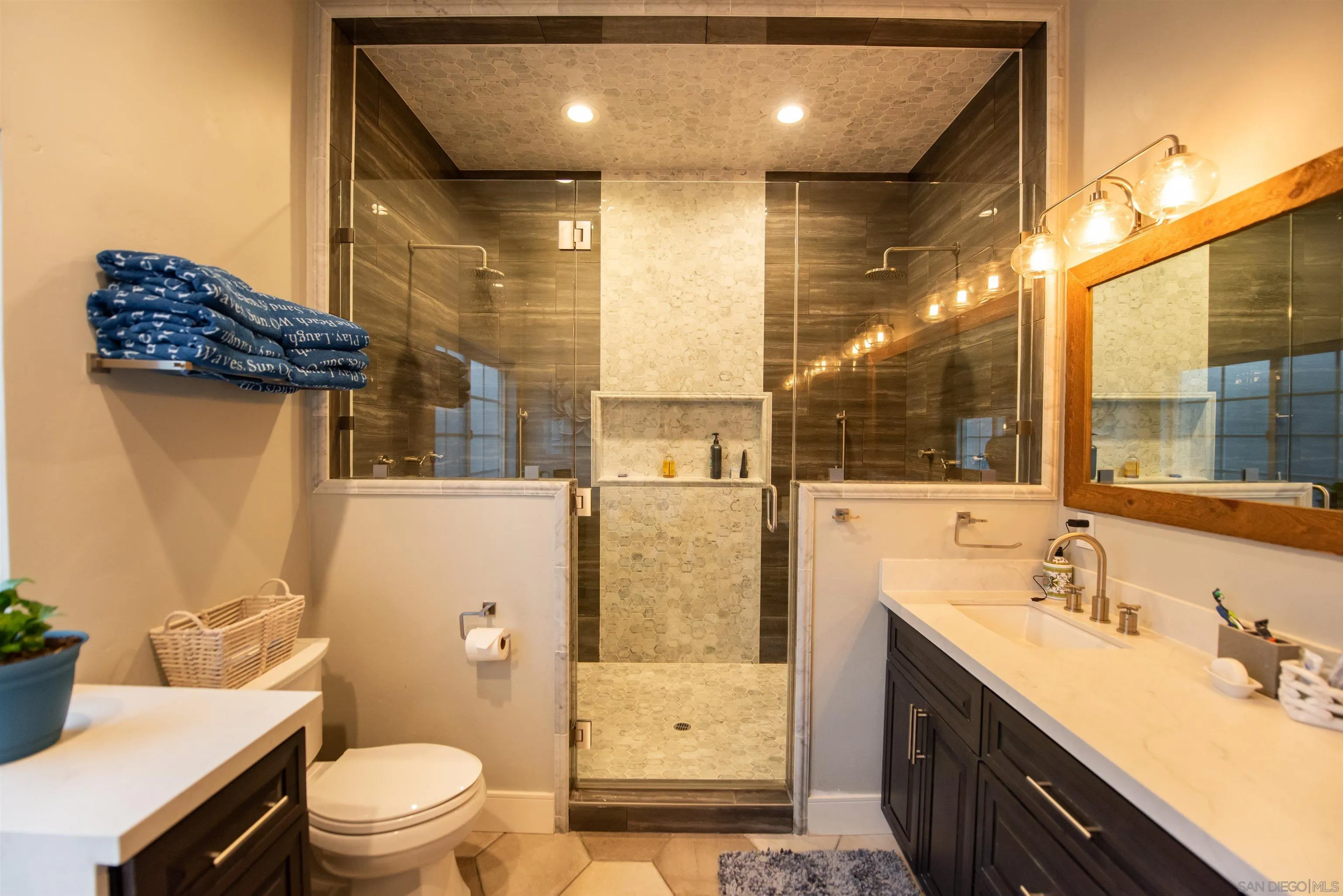 8945 Diamondback Drive Santee, CA 92071 - Photo 21 of 49 a bathroom with a granite countertop sink a toilet a mirror and shower