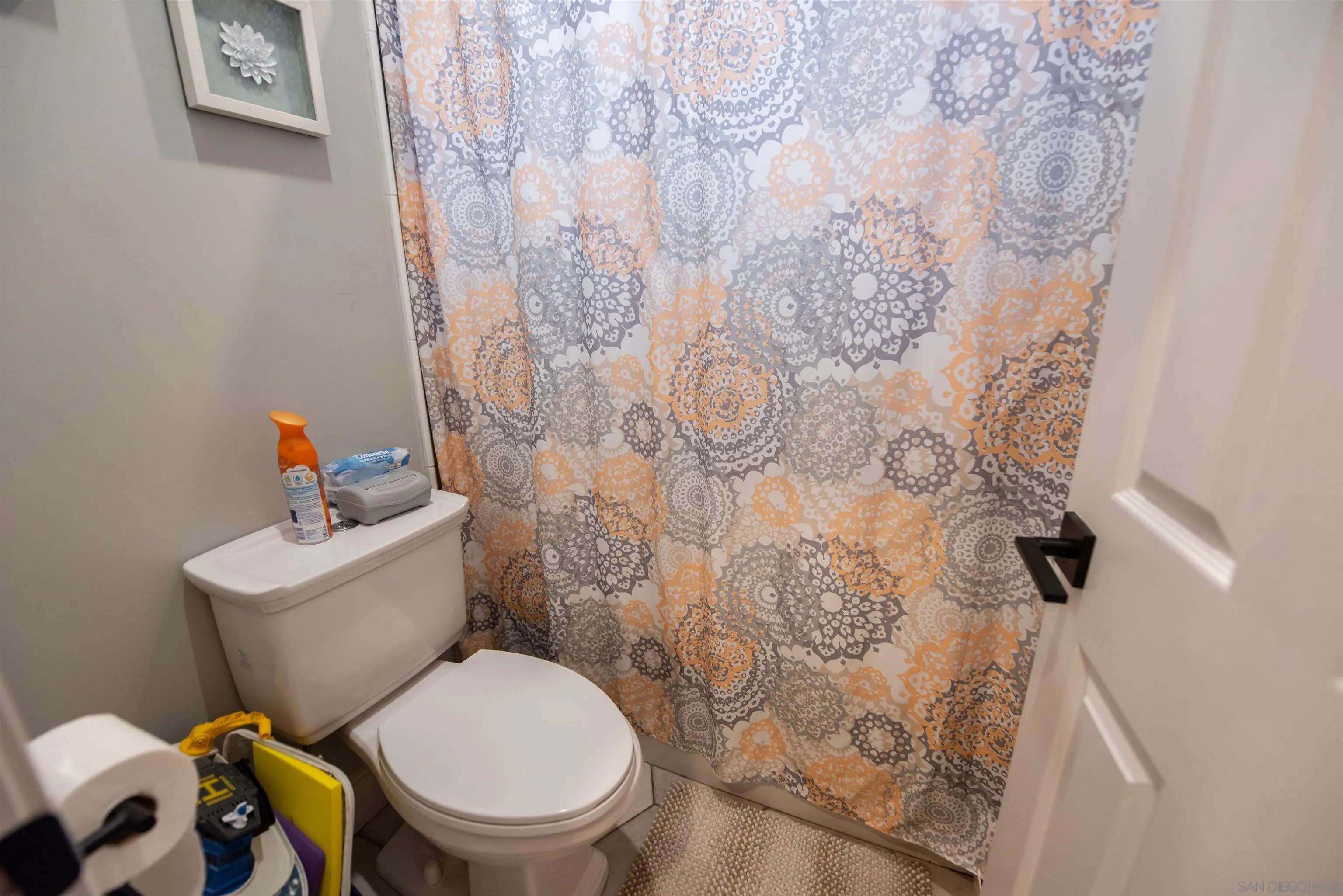 8945 Diamondback Drive Santee, CA 92071 - Photo 32 of 49 a white toilet sitting next to a shower curtain