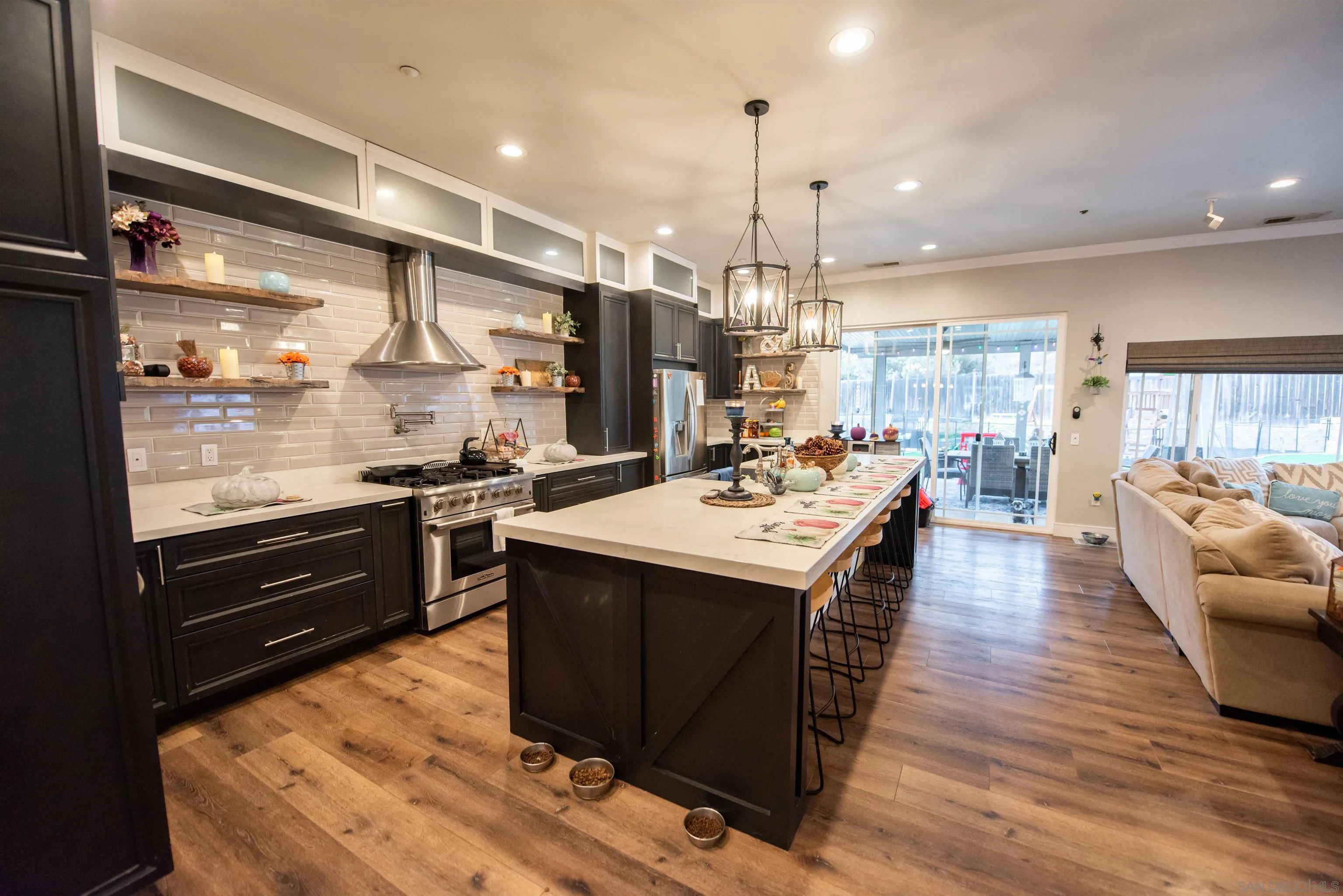 8945 Diamondback Drive Santee, CA 92071 - Photo 34 of 49 a kitchen with stainless steel appliances kitchen island granite countertop a sink a stove and a wooden floor