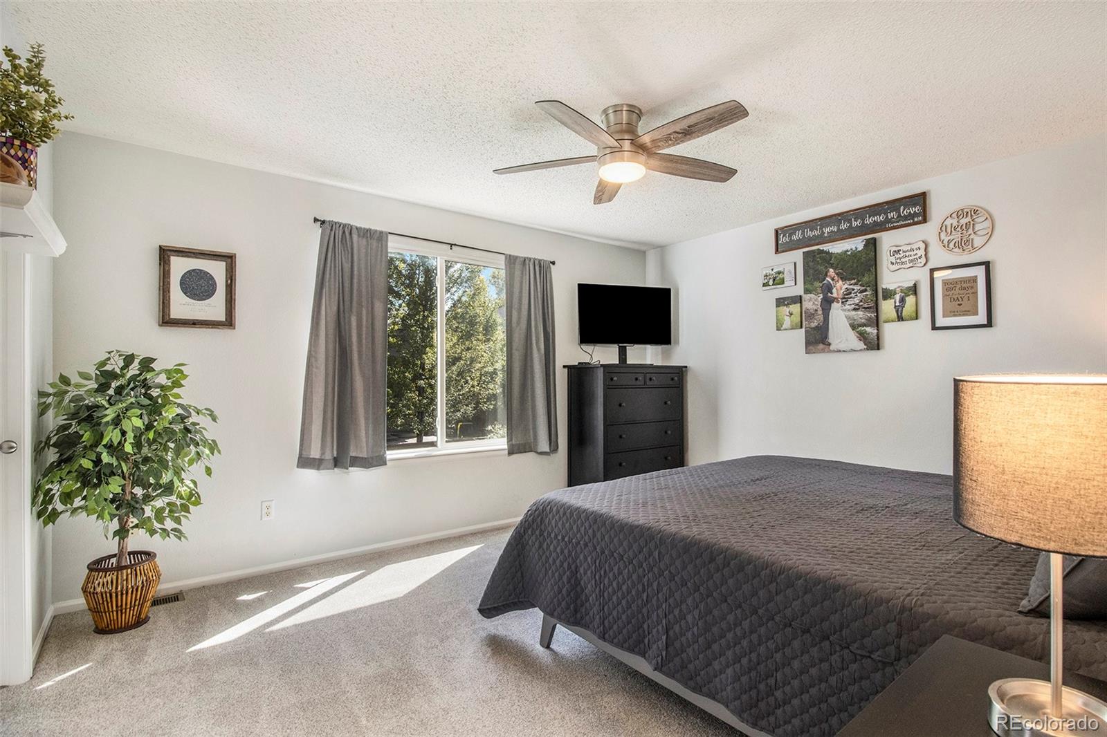 822 Timbervale Trail Highlands Ranch, CO 80129 - Photo 15 of 34 a bedroom with a bed and a chandelier
