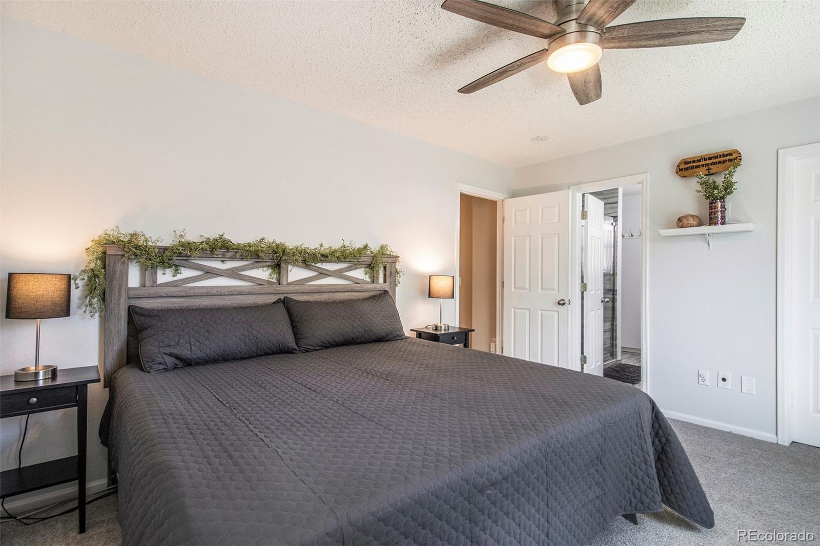 822 Timbervale Trail Highlands Ranch, CO 80129 - Photo 16 of 34 a bedroom with a large bed and a chandelier