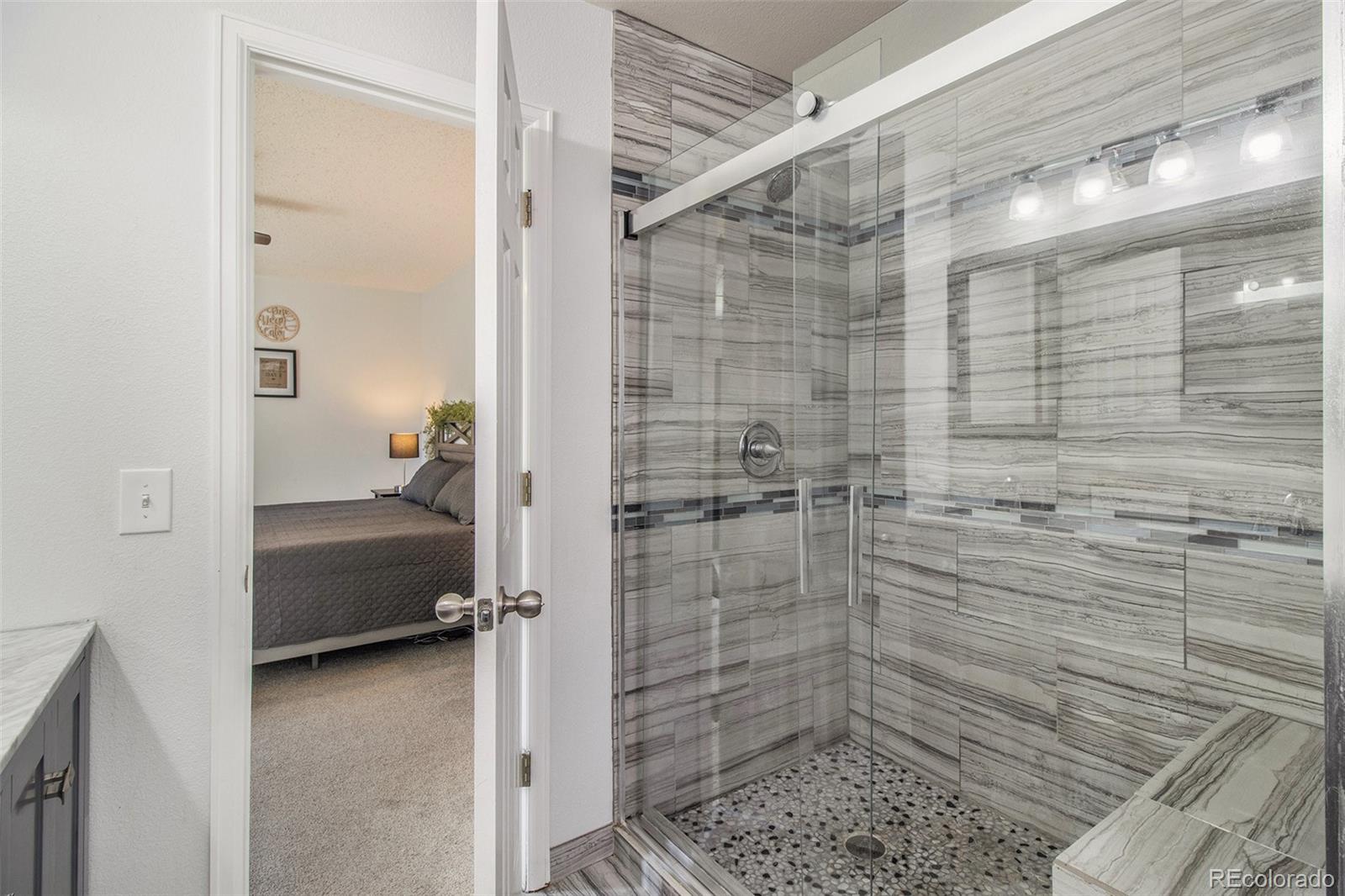 822 Timbervale Trail Highlands Ranch, CO 80129 - Photo 17 of 34 a bathroom with a glass door shower