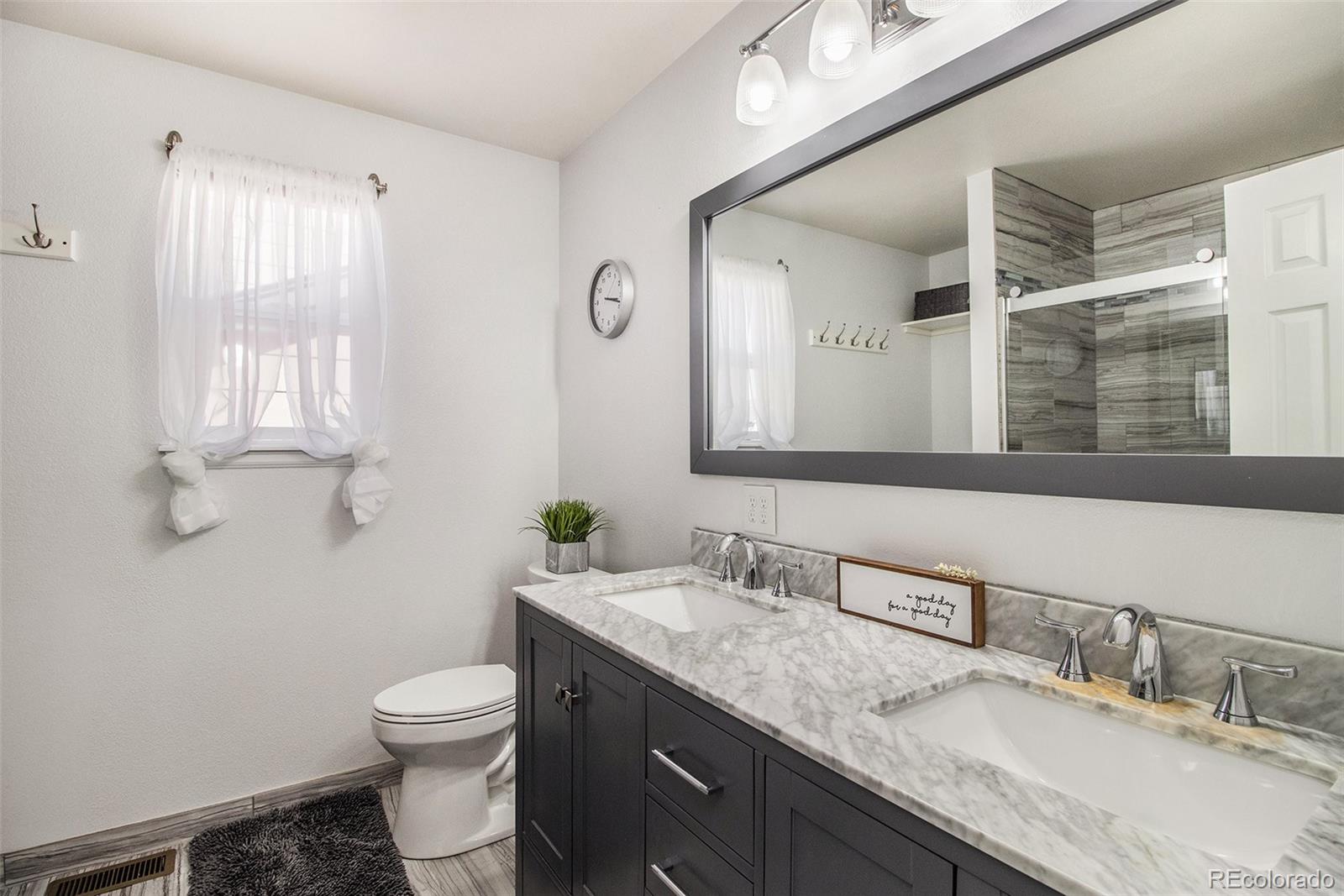 822 Timbervale Trail Highlands Ranch, CO 80129 - Photo 18 of 34 a bathroom with a granite countertop sink mirror and toilet