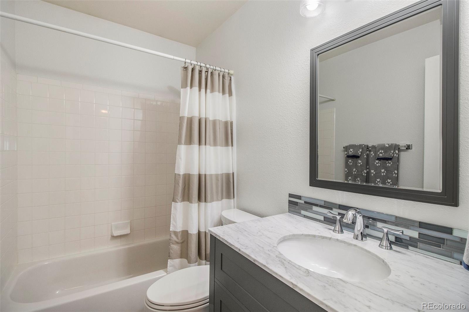 822 Timbervale Trail Highlands Ranch, CO 80129 - Photo 19 of 34 a bathroom with a granite countertop sink toilet and shower