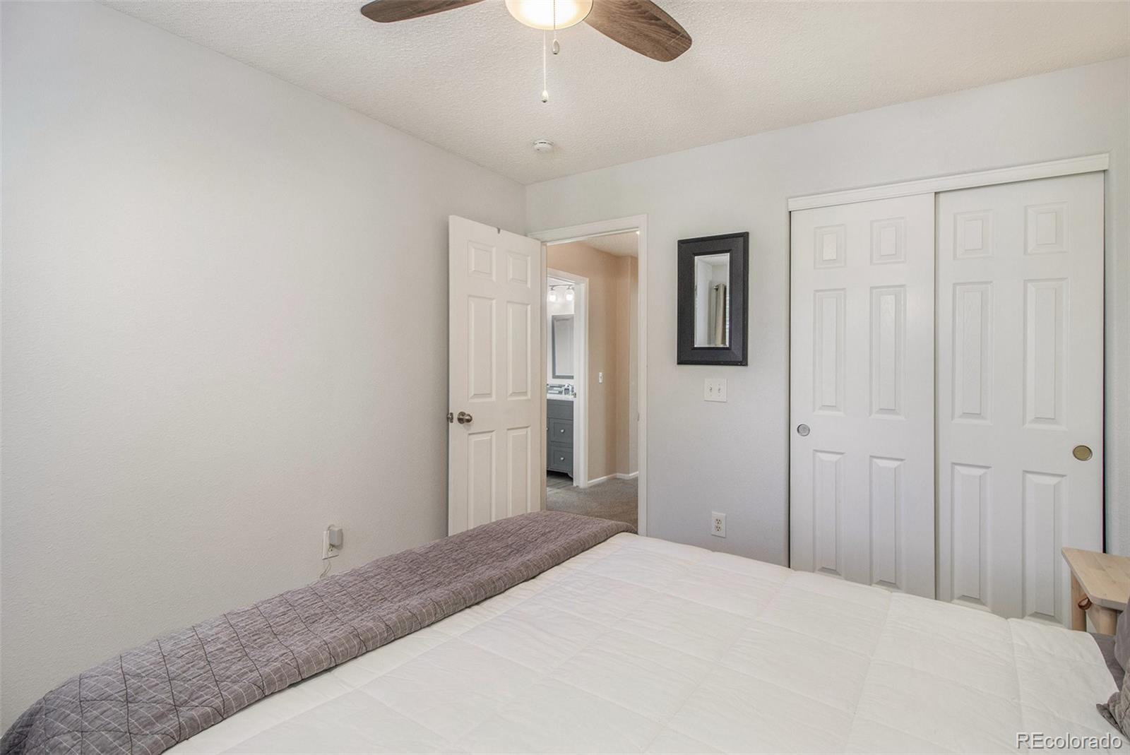 822 Timbervale Trail Highlands Ranch, CO 80129 - Photo 25 of 34 a bedroom with a bed and a chandelier fan