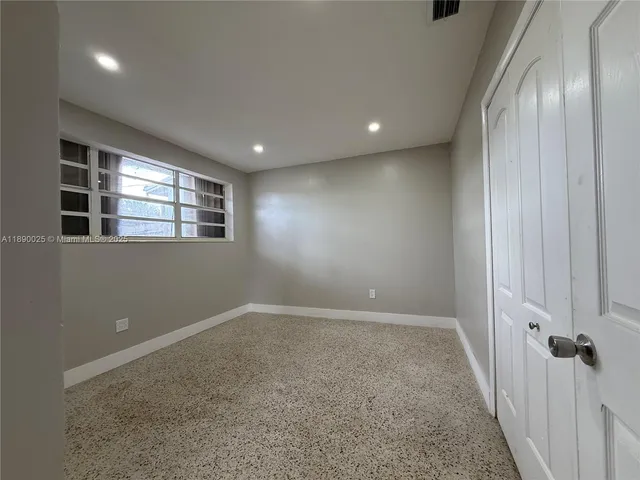 an empty room with windows and closet