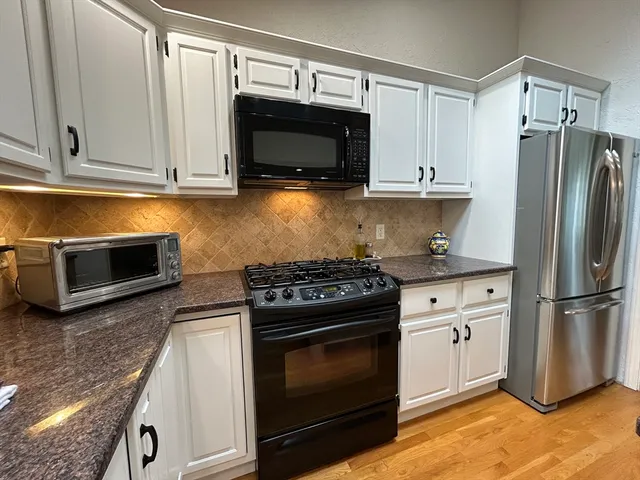 a kitchen with stainless steel appliances granite countertop a stove microwave and refrigerator