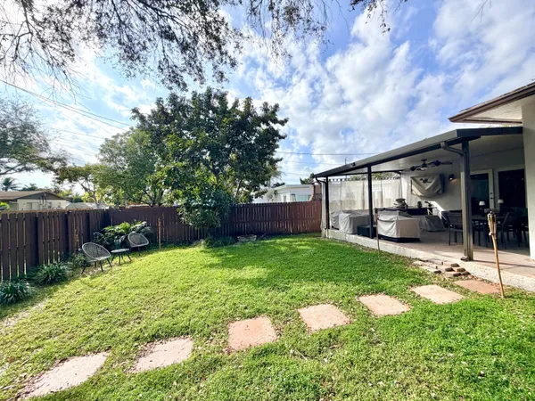 a view of backyard with table and chairs and wooden fence