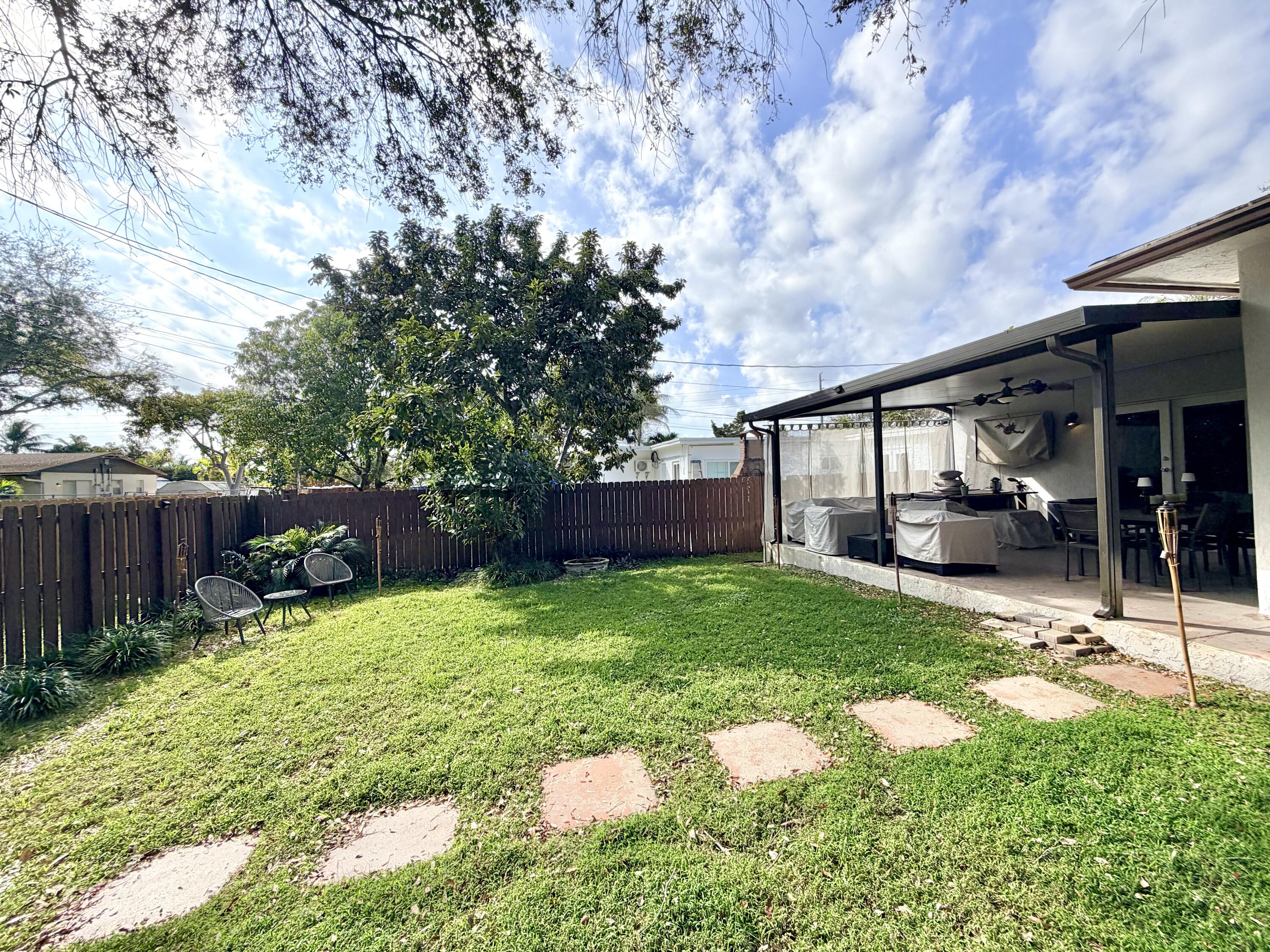 243 Southwest 5th Street Dania Beach, FL 33004 - Photo 12 of 18 a view of backyard with table and chairs and wooden fence