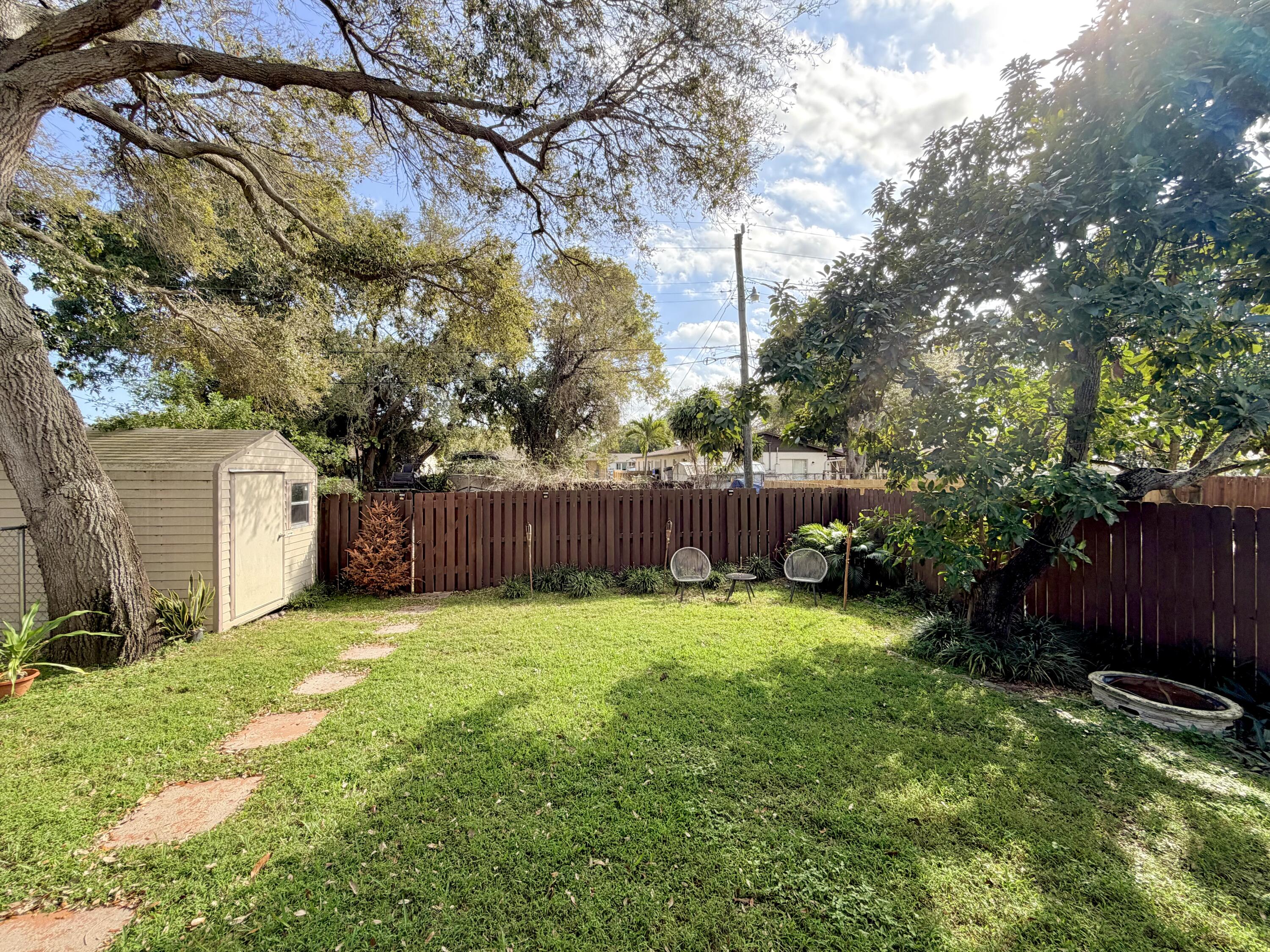 243 Southwest 5th Street Dania Beach, FL 33004 - Photo 13 of 18 a view of a backyard with large trees and wooden fence