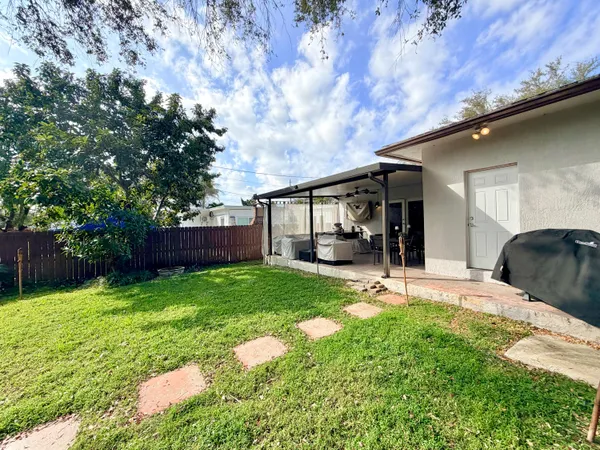 a view of a backyard with sitting area and tree