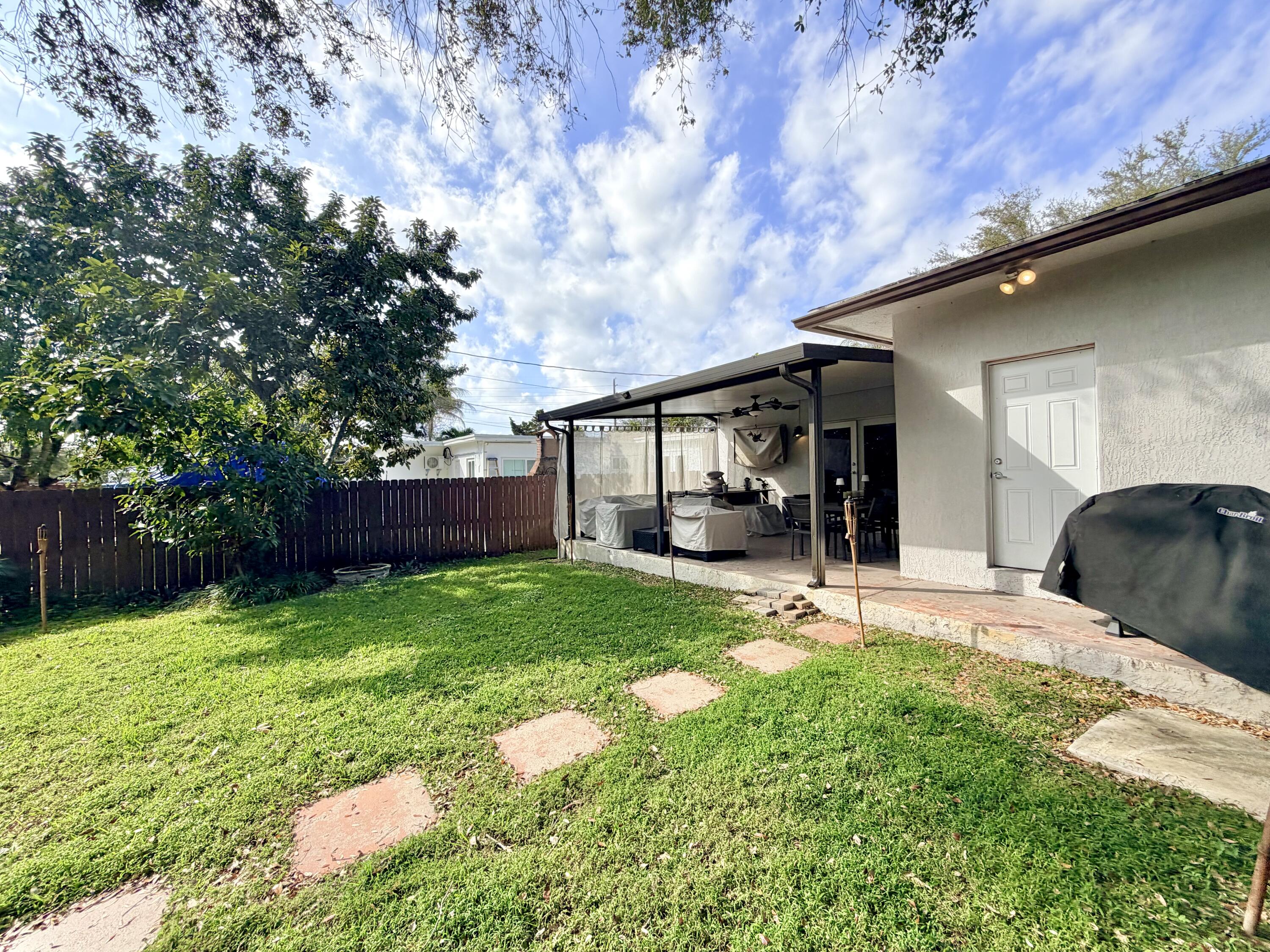 243 Southwest 5th Street Dania Beach, FL 33004 - Photo 15 of 18 a view of a backyard with sitting area and tree