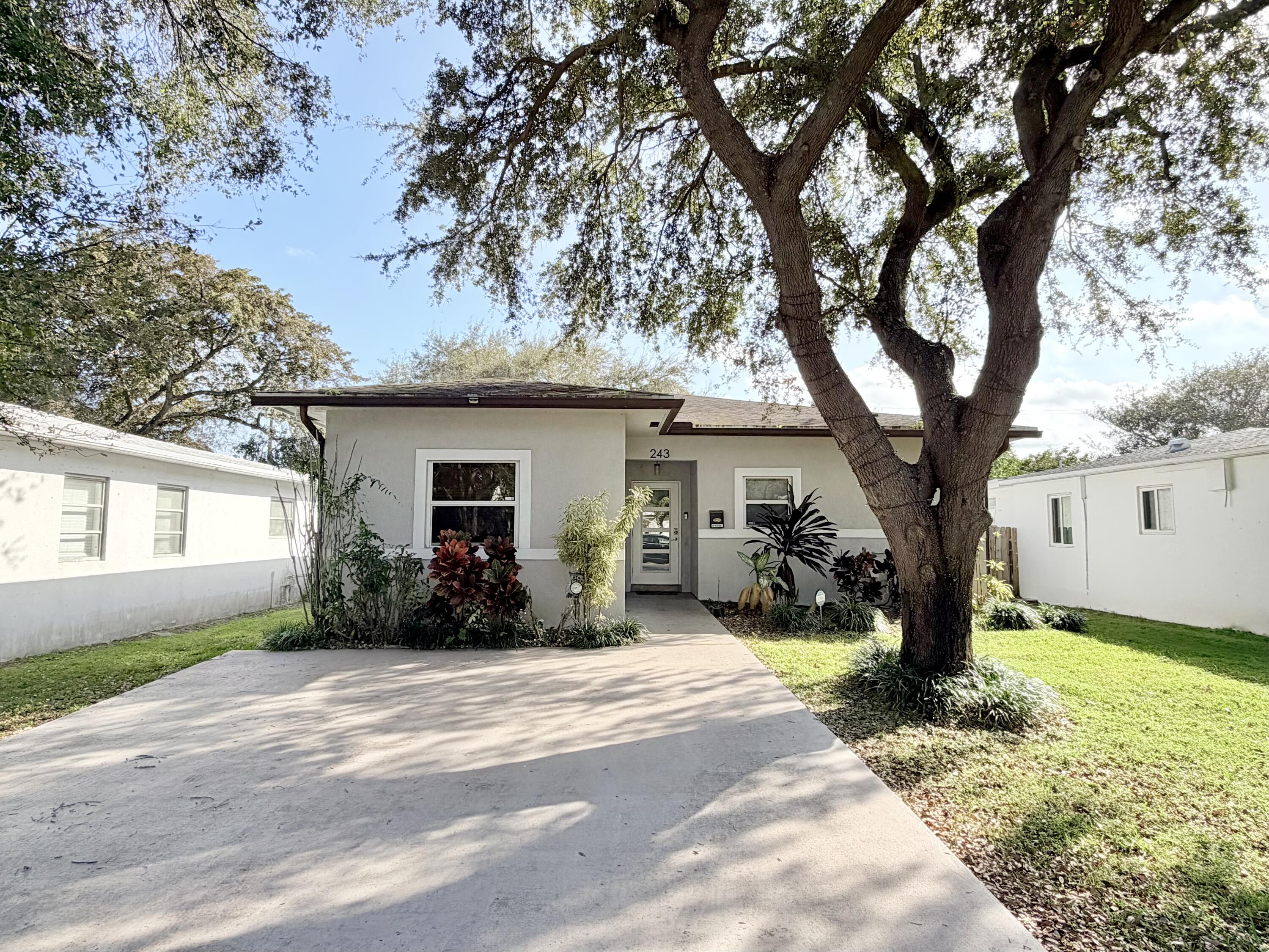 243 Southwest 5th Street Dania Beach, FL 33004 - Photo 18 of 18 a front view of a house with a yard and potted plants