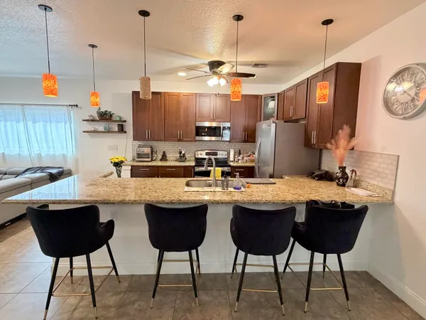 a kitchen with a dining table chairs sink and cabinets